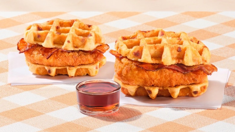 Two Chicken & Waffle Sandwiches from Chick-fil-A, with a side of syrup