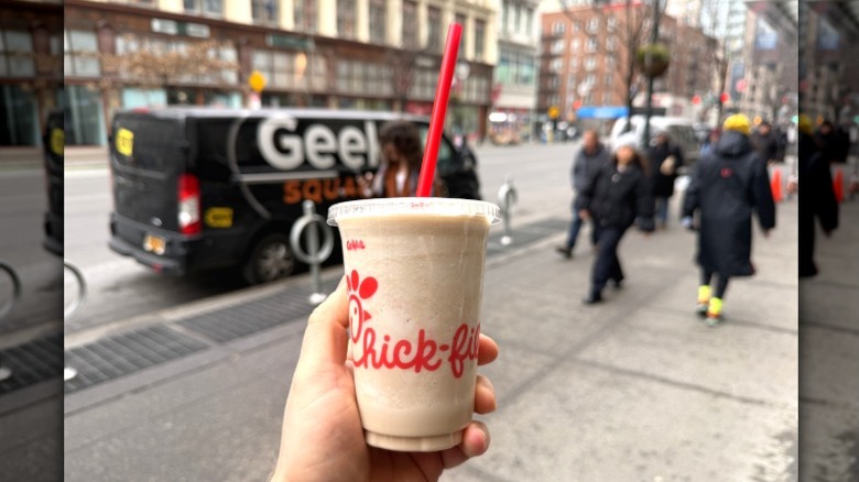 A Chick-fil-A frosted soda in a person's hand on a street in New York City