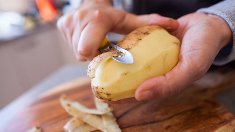Person peeling potato