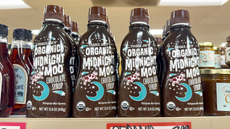 Bottles of Trader Joe's Midnight Moo chocolate syrup lined up on a shelf