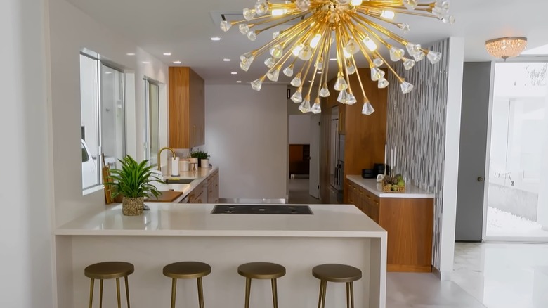 Finished modern kitchen reno with a peninsula designed by Christina Haack