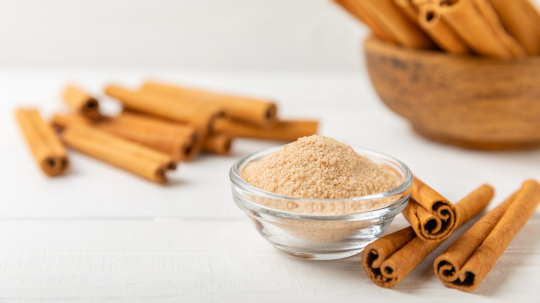 Cinnamon sugar in bowl with cinnamon sticks