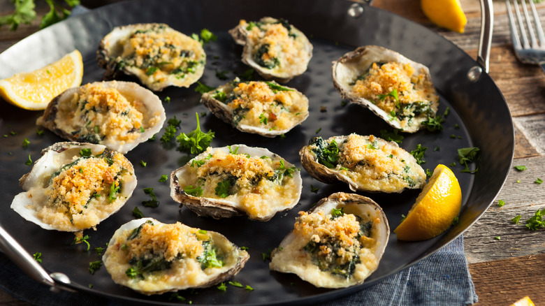 Skillet of Oysters Rockefeller on wood table