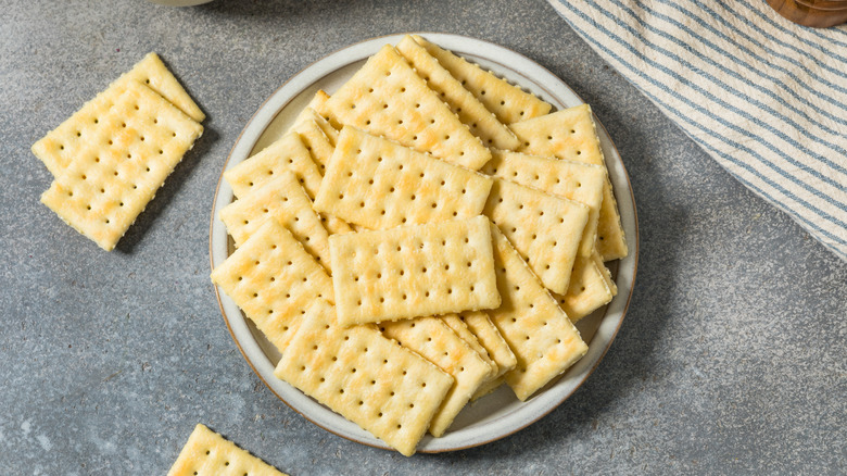 A plate overflowing with club crackers on a granite background