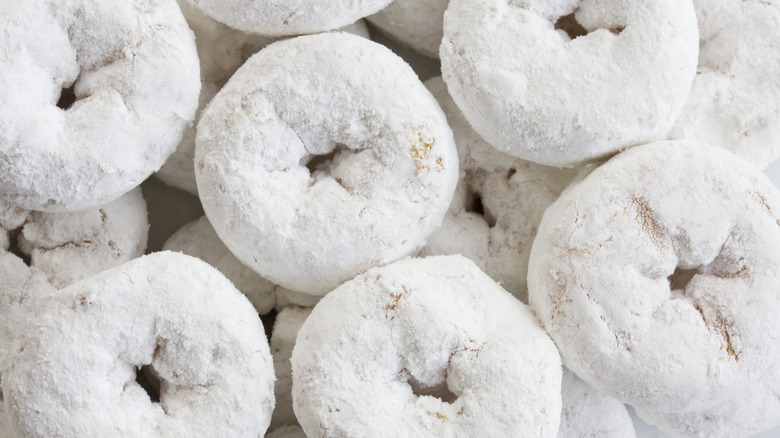 A close-up of powdered sugar donuts filling the frame