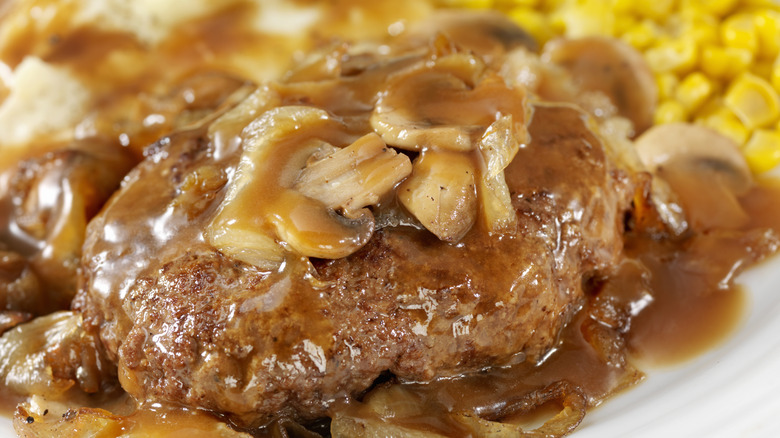 A close-up of salisbury steak with gravy and mushrooms