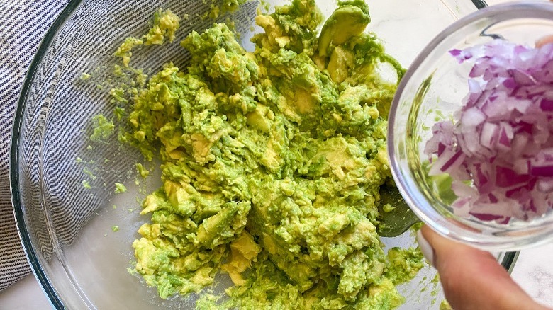 mashed avocado in bowl with red onion  Fleet and Straightforward Guacamole add your additional seasonings 1664204141