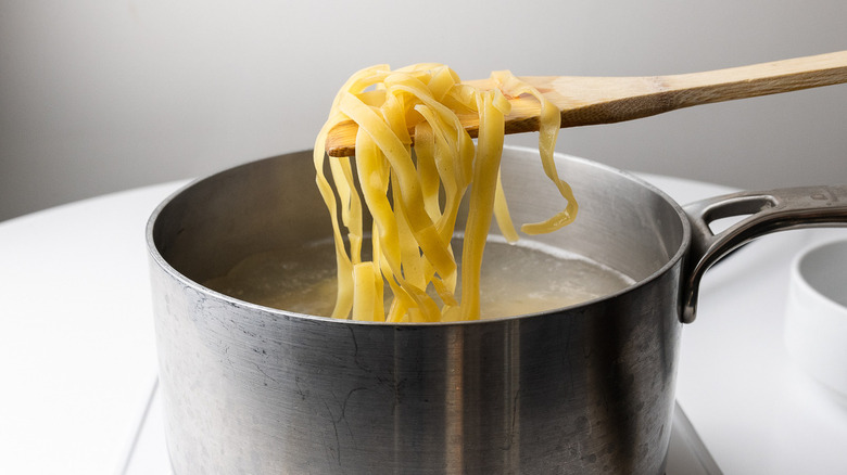 cooked pasta on wooden spoon