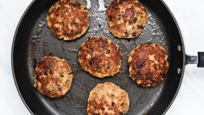 burger patties frying in skillet