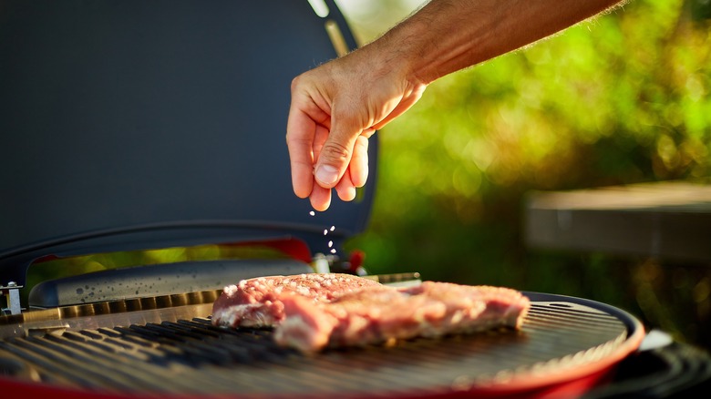 salting steak on the grill