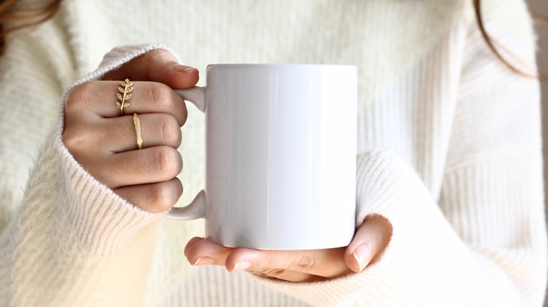 woman holding white mug