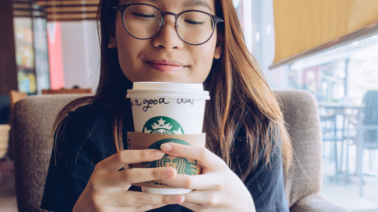 Woman smiling with Starbucks coffee