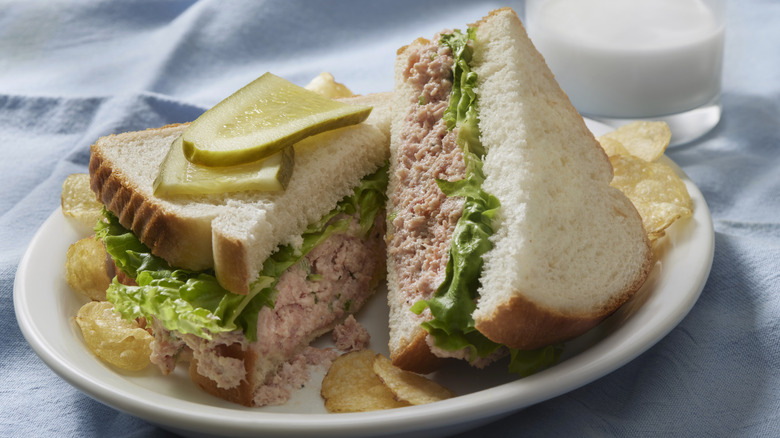Deviled ham sandwiches with potato chips and a dill pickle