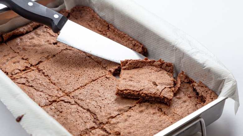 Overly thin brownies in a flat pan with a knife