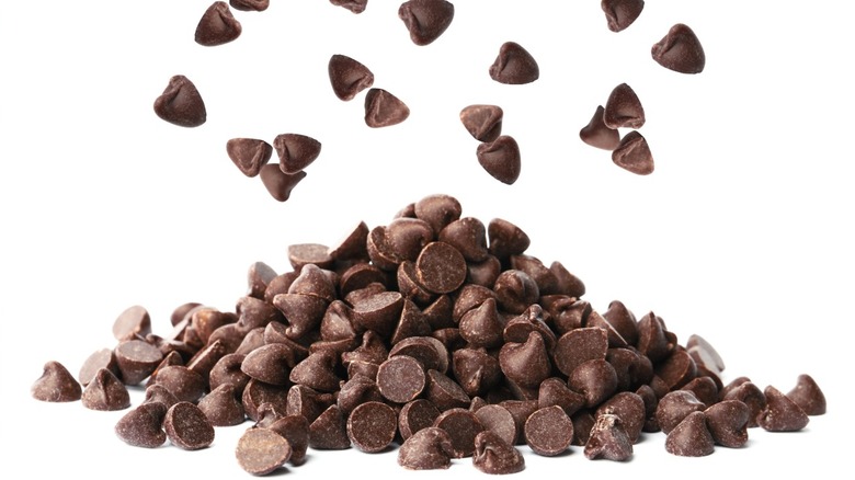 A pile of chocolate chips on a white table with a white background