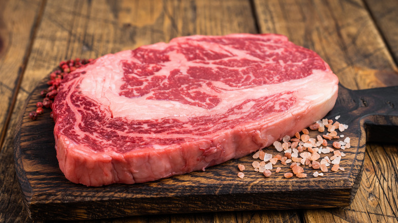 A raw cut of ribeye showing thick marbling