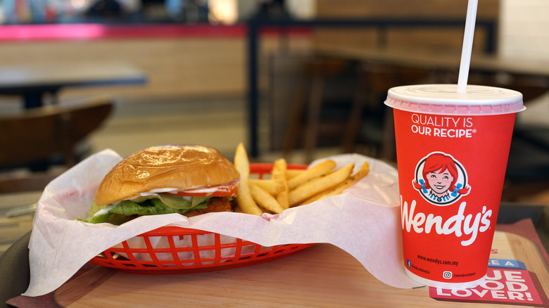 wendy's burger served in basket alongside soft drink