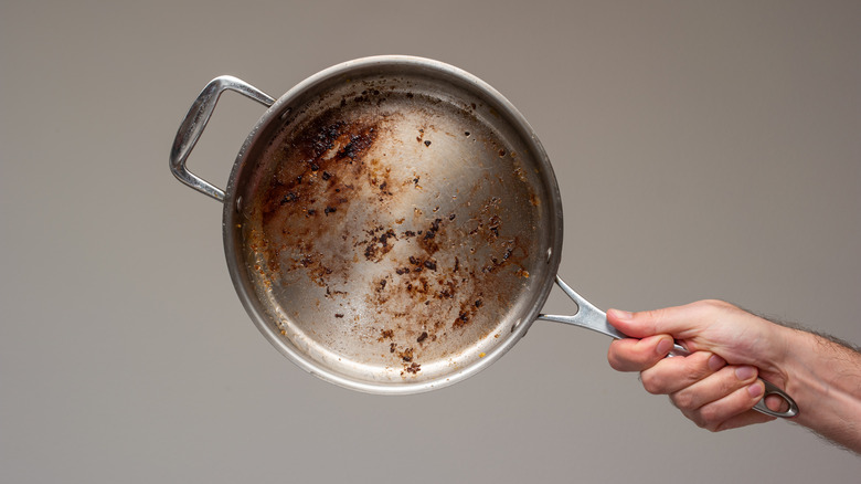 Hand holding dirty pan