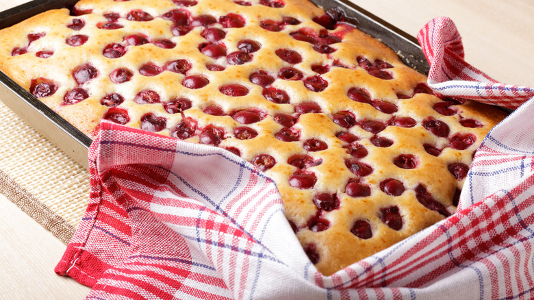cherry cake in pan with tea towel