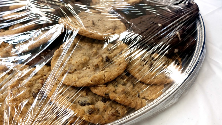 A plate of cookies covered in saran wrap 