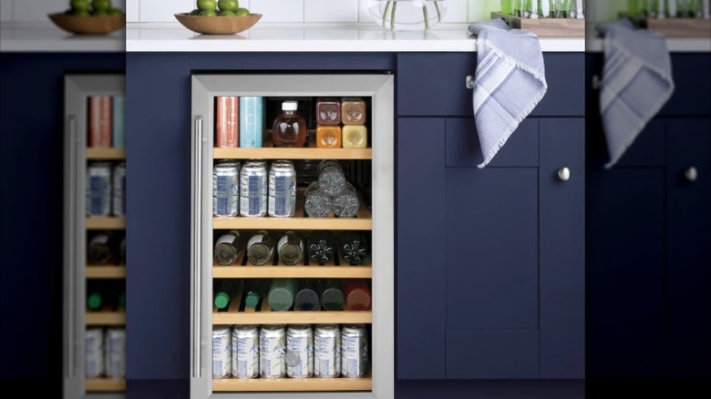 a blue kitchen cupboard with an inbuilt stainless steel drinks refrigerator