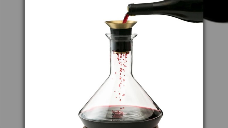 red wine being poured into a transparent decanter