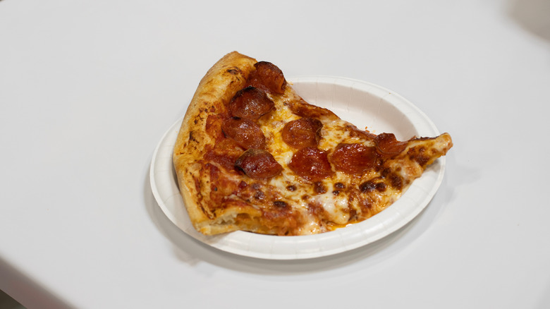 A slice of pepperoni pizza on a plastic plate