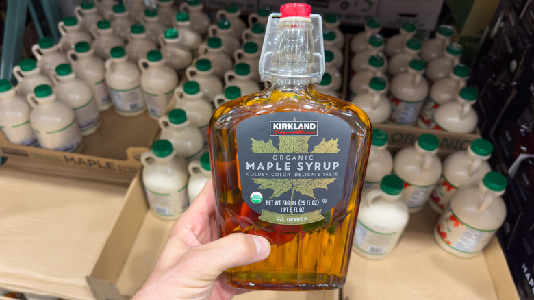 shopper holding container of kirkland maple syrup