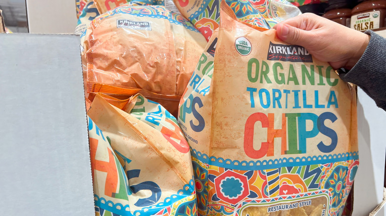 Hand grabbing bag of Organic Tortilla Chips