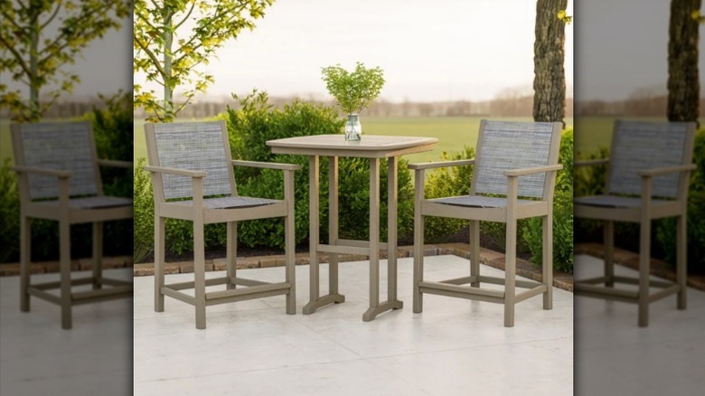 Camden outdoor patio set outside by bushes and trees