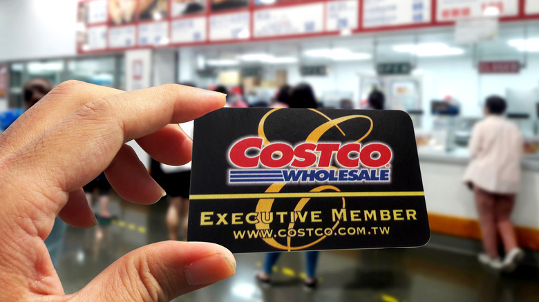 Costco member holding up executive card