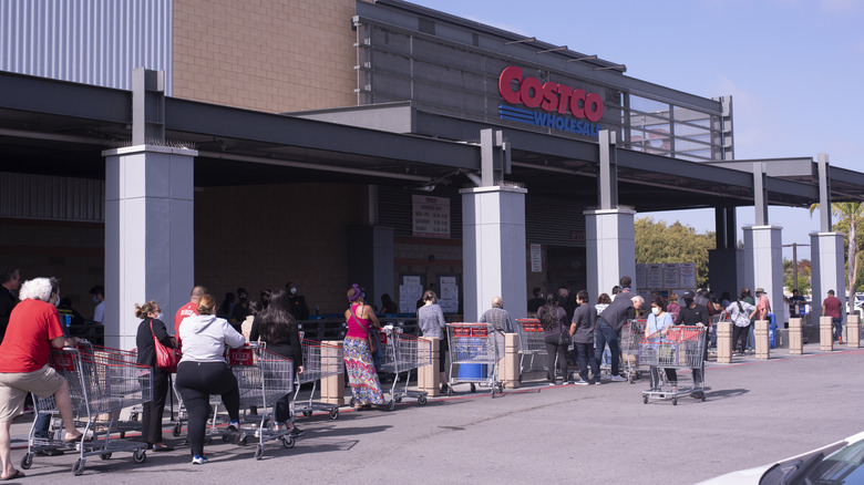 Shoppers in a line outside the entrance of a Costco outlet