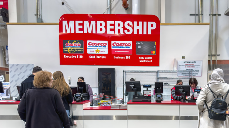 A Costco membership station with employees working and customers waiting