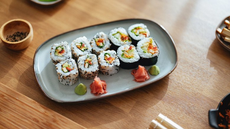 sushi roll cut up with wasabi and ginger on the side