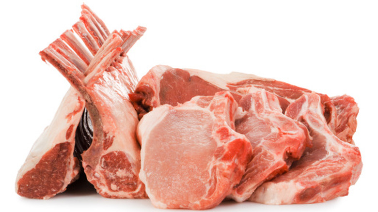 stack of different meats include ribeye steaks, pork chops, and rack of lamb