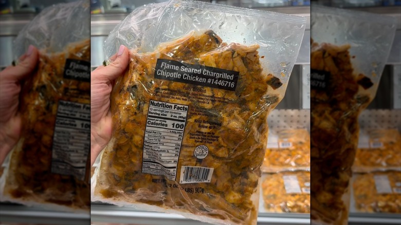 Hand holding package of Flame Seared Chargrilled Chipotle Chicken in Costco.