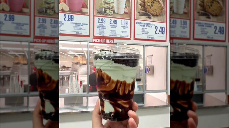 a hand holding up the double chocolate mint sundae at the costco food court