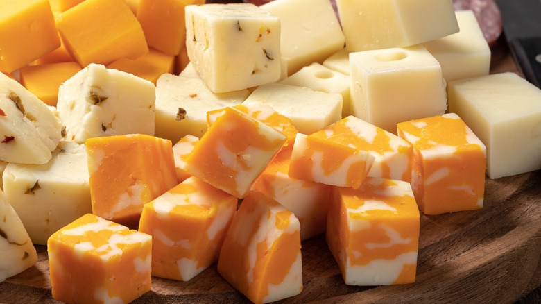 various cubed cheese types on a board