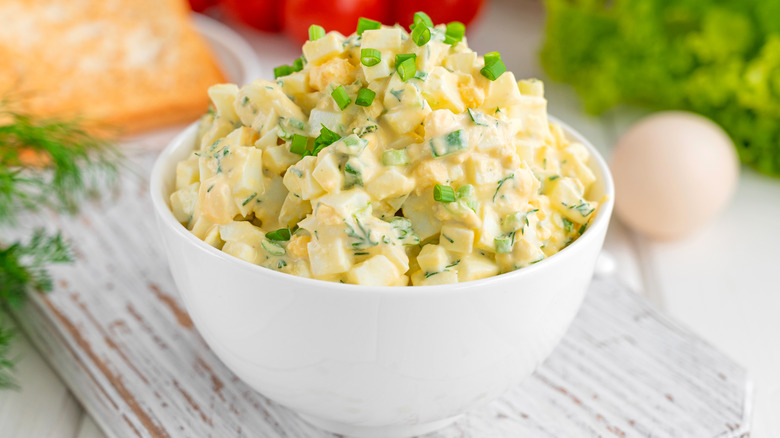 Egg salad in a bowl topped with scallions