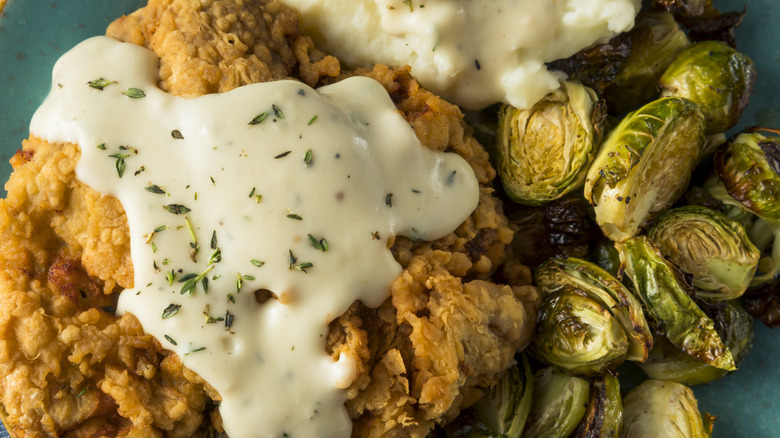 Close-up of chicken fried steak with Brussels sprouts and mashed potatoes