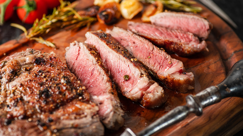 cooked ribeye steak on a board