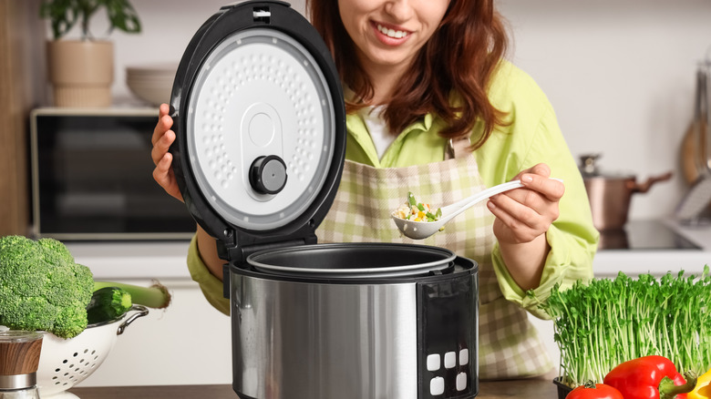 someone putting vegetables in rice cooker