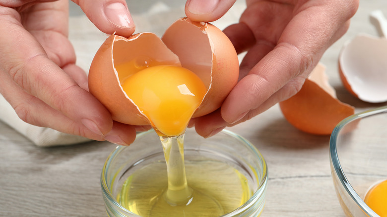 Cook separating egg yolk