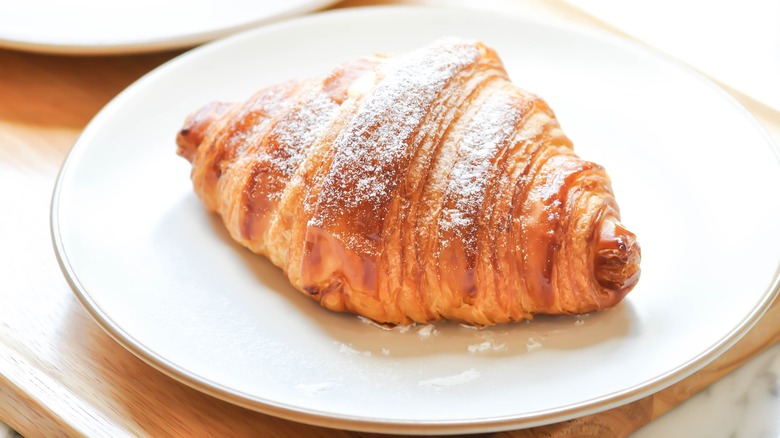 plate holding sugar powdered croissant
