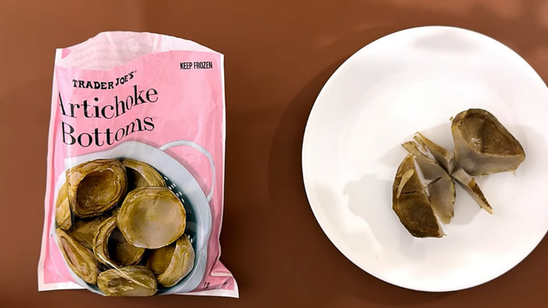 a bag of Trader Joe's artichoke bottoms next to a plate with an artichoke bottom sliced in half