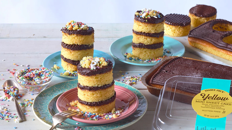 plates with circular servings of yellow sheet cake with chocolate icing and sprinkles and a couple of open packages of Trader Joe's yellow mini sheet cakes on a table