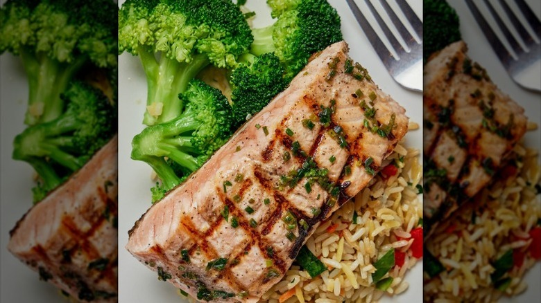 a plate of grilled salmon, broccoli, and rice