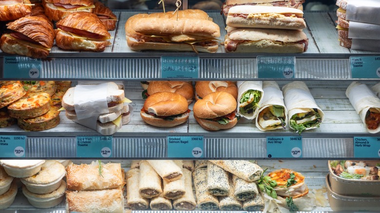 A variety of sandwiches arranged on shelves in a refridgerated case