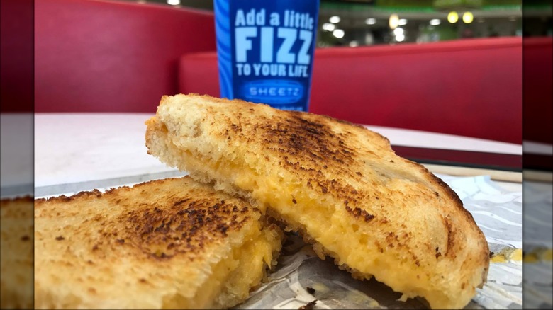 A close-up of a grilled cheese from Sheetz with a blue drink in the background