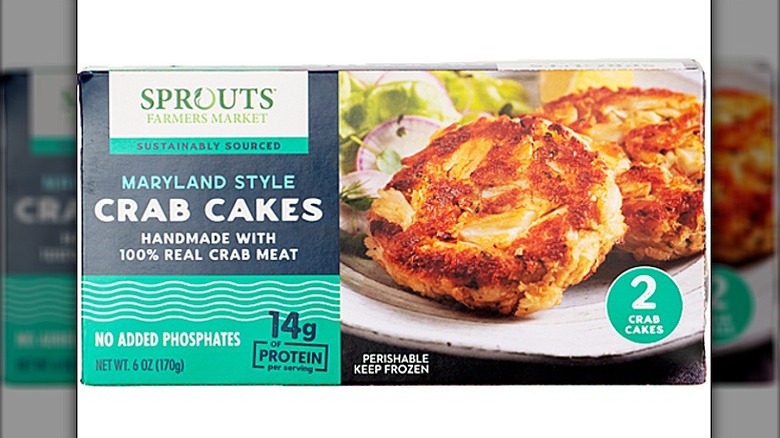 A box of Sprouts Farmers Market Maryland Style Crab Cakes with a photo of 2 cooked crab cakes on a plate, with garnish
